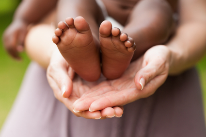 baby feet in adoptive mother's hands