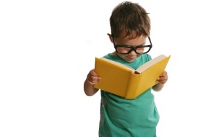 child with glasses reading a book